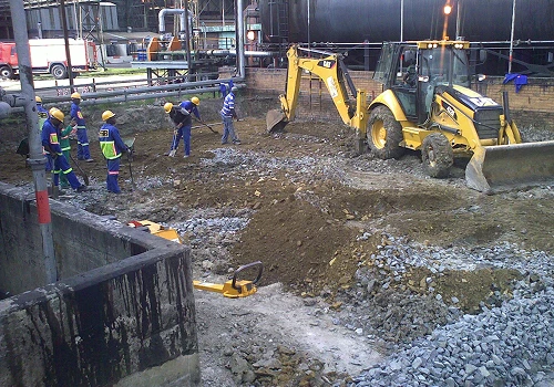 Crew installing bulk fuel oil storage tanks at an industrial site.