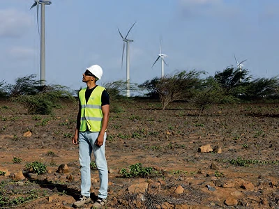 A project sponsor observing wind turbines at a renewable energy site.