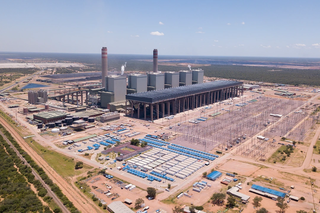 Aerial view of a large power plant, showcasing its extensive infrastructure and surrounding landscape.
